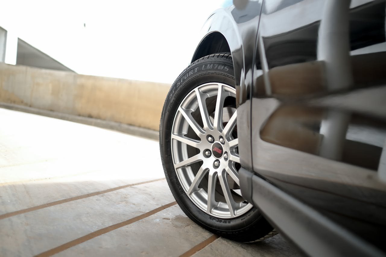 Macro view of a car wheel showing reflective paint and alloy rim for automotive design inspiration.