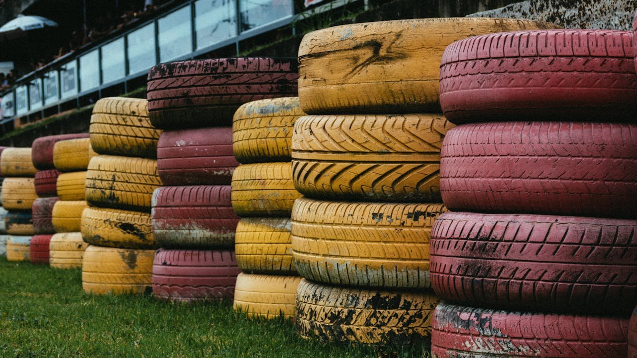Stacks of colorful red and yellow tires arranged outdoors, perfect for recycling themes.